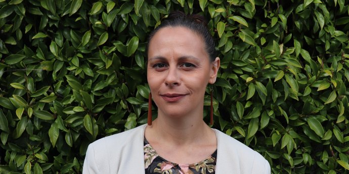 Jenna Neame headshot with green leaves background